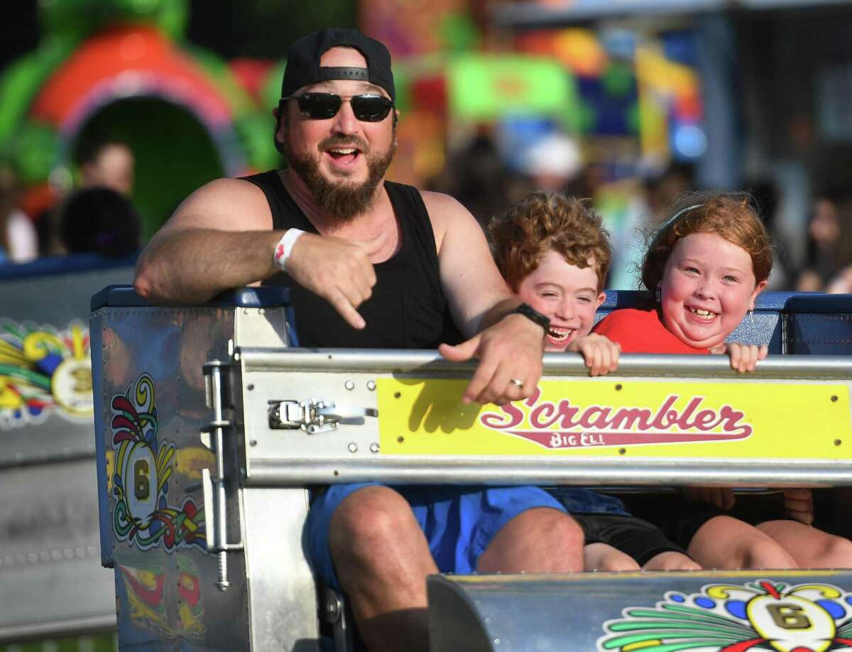 From left; Oliver, Harlan, 6, and Mabel Keating, 7, of Trumbull, enjoy one of the rides during the opening evening of Trumbull Day festivities Friday.