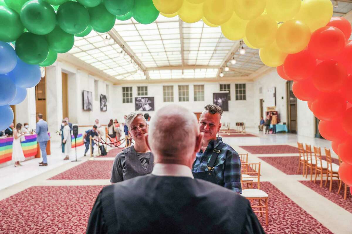 Danni Fox, 48 (left), and Jak Kazmarek, 46, get married at City Hall during a special Pride celebration last month.