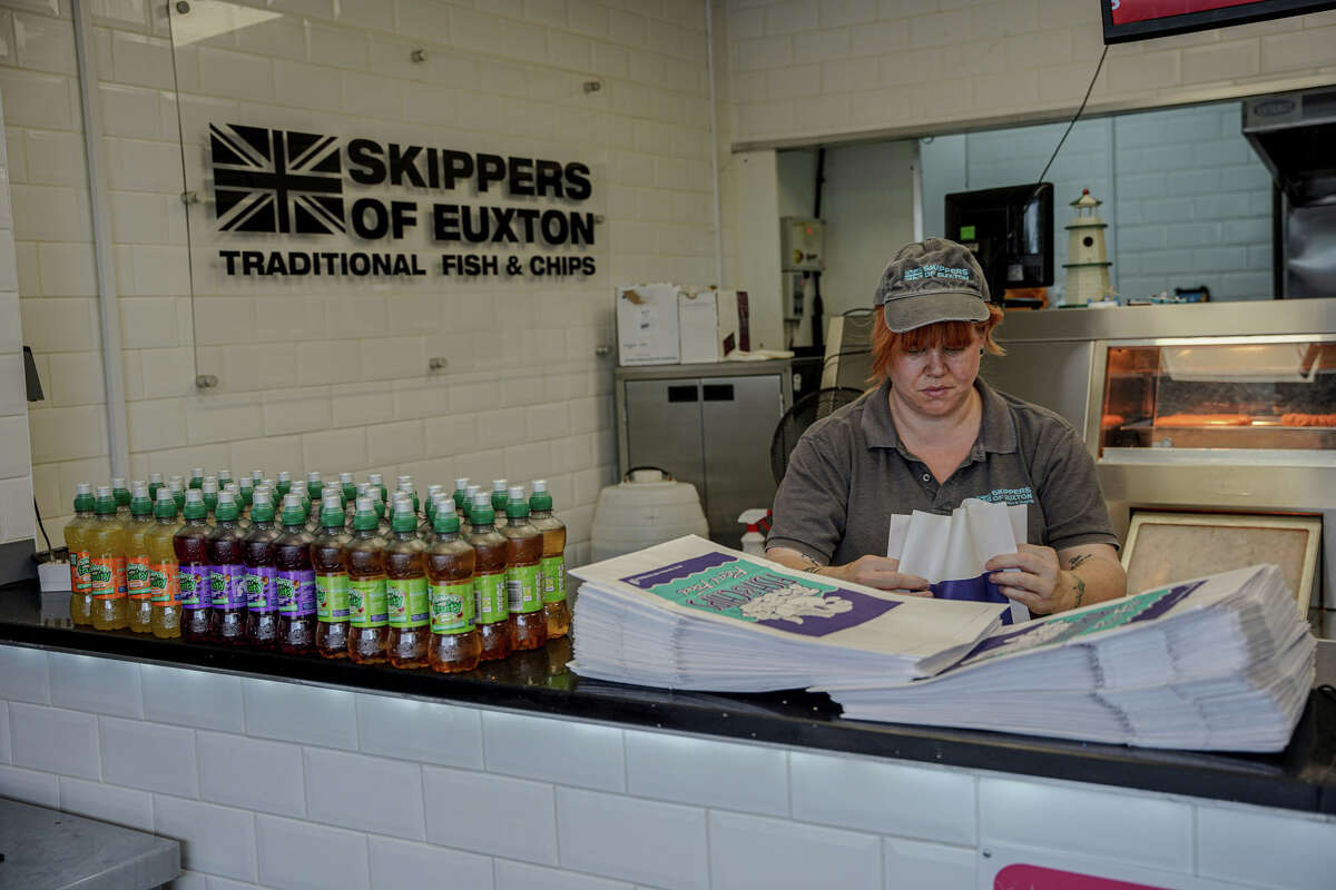 Lorraine Agent packs a customer's order at Skippers of Euxton, another fish and chip shop just outside Preston, England.