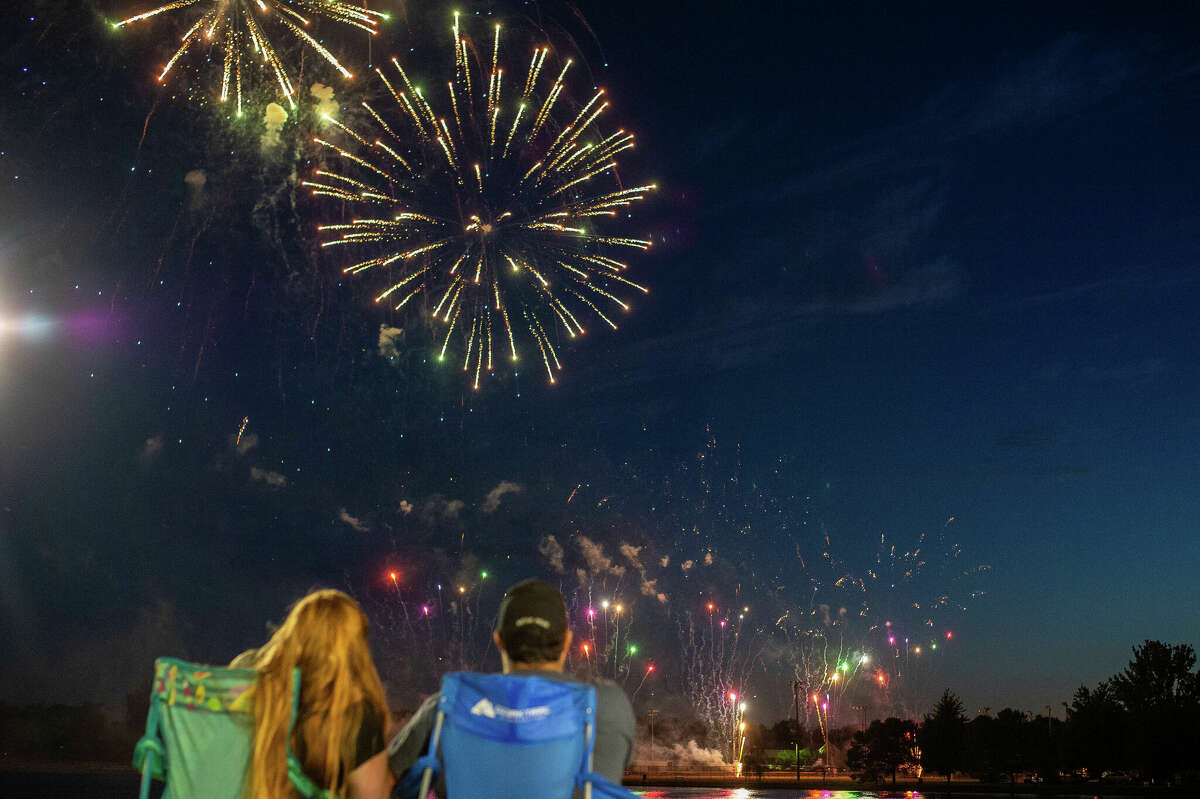 People gather to watch a fireworks display on July 1, 2022 along the Saginaw River in Bay City.