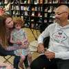 Jerry Craft, right, the author of a book once pulled from Katy ISD libraries over concerns about "critical race theory,"signing books at Brown Sugar Cafe and Books in Katy on July 1, 2022. He is signing for Sarah Cardnell and her daughter, Lucy.