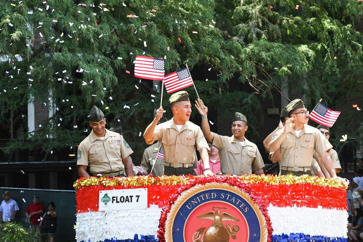 A float carrying members of the U.S. Marine Corps is cheered on during the Armed Forces River Parade on Saturday, July 2, 2022.