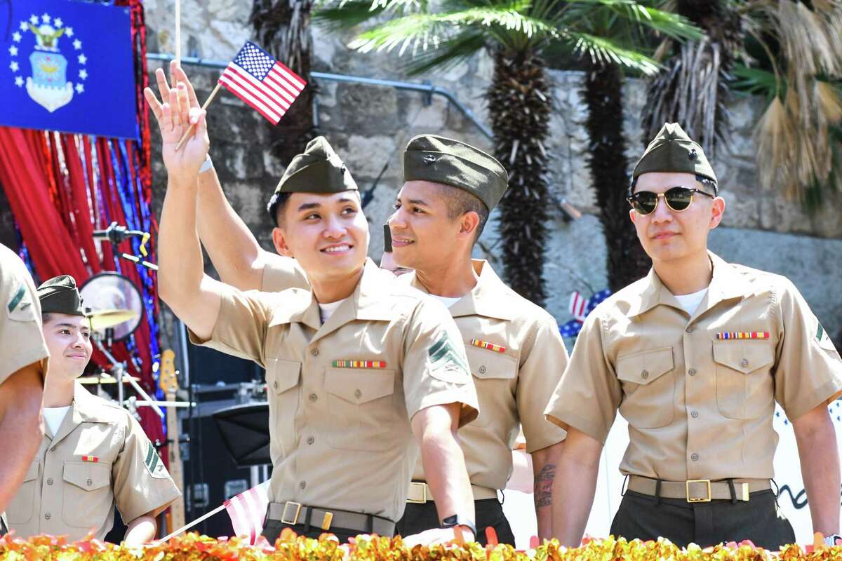 Members of the U.S. Marine Corps waves to the crowd Saturday, July 2, 2022, while floating down the river during the Armed Forces River Parade.