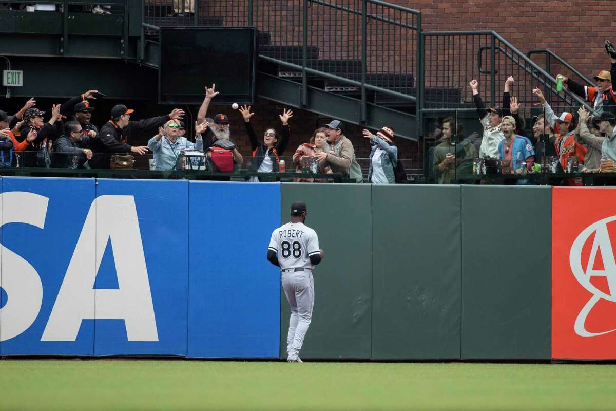Chicago White Sox’s Luis Robert watches as fans catch a home run ball hit by LaMonte Wade Jr. in the outfield during the first inning of a MLB baseball game against the San Francisco Giants in San Francisco, Calif. Saturday, July 2, 2022.