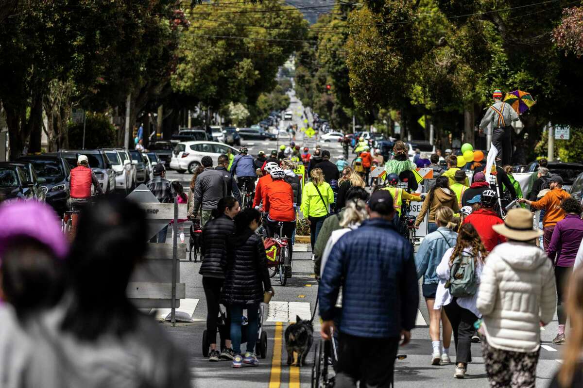 4月30日星期六，在加州旧金山里士满社区举行的支持慢街的社区游行中，人们沿着湖街步行或骑车。