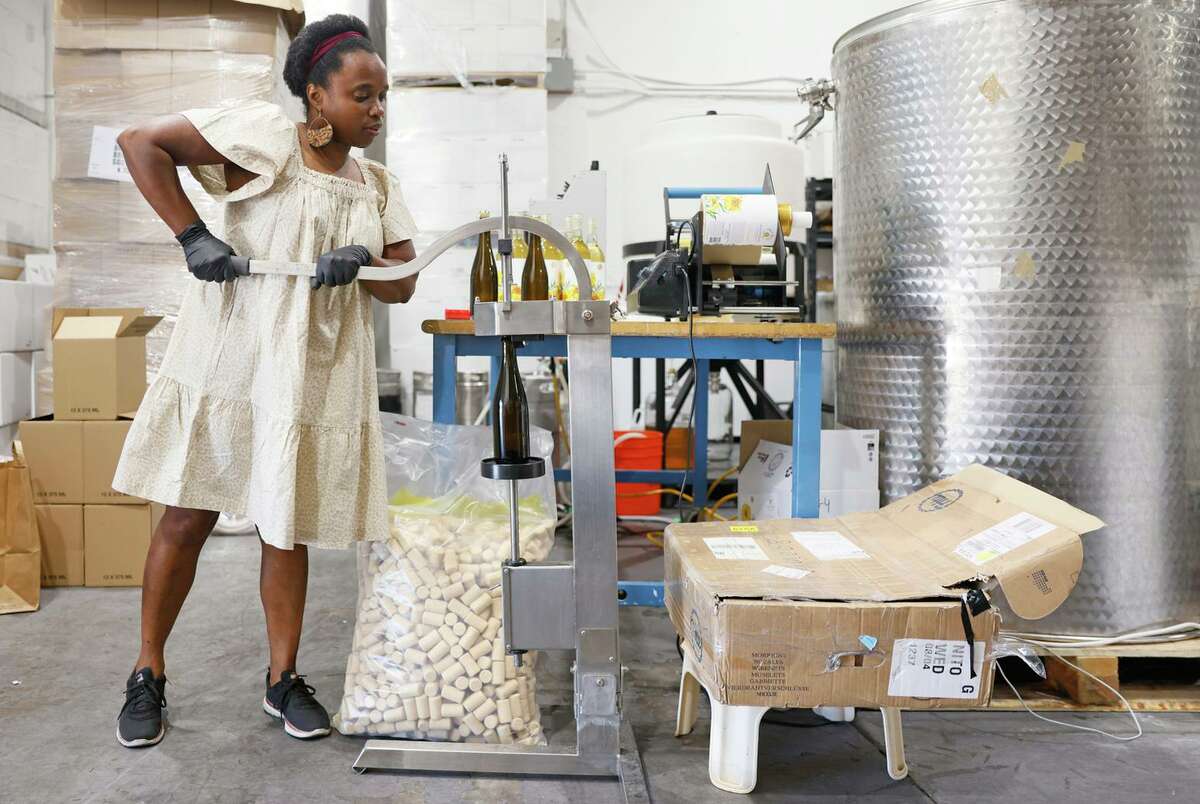 Vintner Aaliyah Nitoto seals a wine bottle with a cork at Free Range Flower Winery in Livermore.