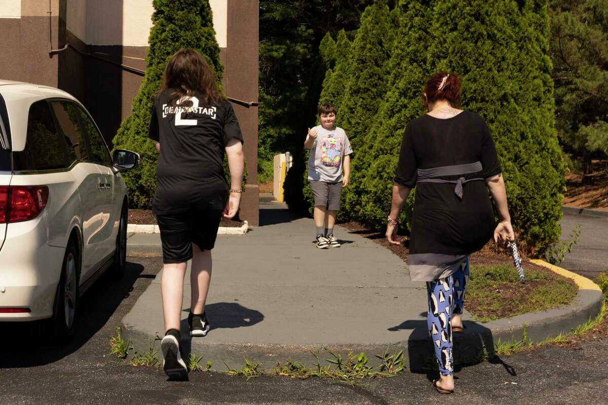 Gavin Barger gestures to his brother, Aiden Turner, and his mother, Sabrina Barger-Turner, to walk faster toward their hotel on June 30 in Towson, Md.