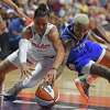 Washington Mystics guard Natasha Cloud and Connecticut Sun guard Courtney Williams dive after a loose ball in a WNBA Eastern Conference basketball game, Sunday, July 3, 2022, in Uncasville, Conn. (Sean D. Elliot/The Day via AP)