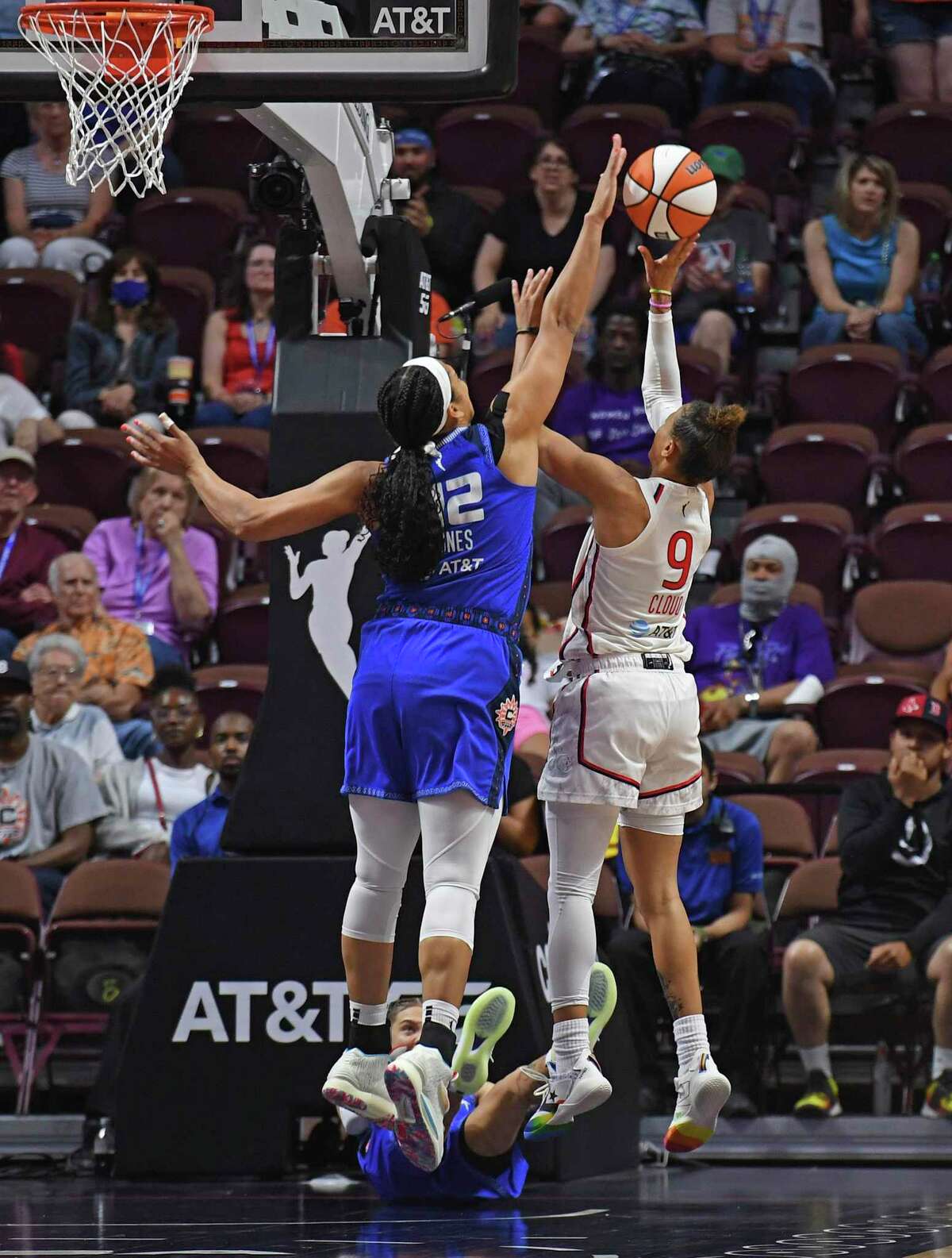 Connecticut Sun center Brionna Jones, left, blocks a potential game-tying shot by Washington Mystics guard Natasha Cloud (9) during overtime Sunday.
