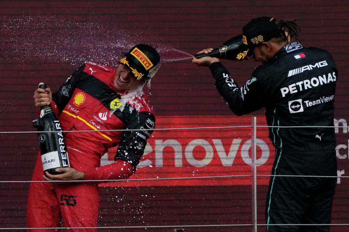 Ferrari driver Carlos Sainz of Spain, left, celebrates with third-place Mercedes driver Lewis Hamilton of Britain on the podium after winning Formula One’s British Grand Prix in Silverstone, England.