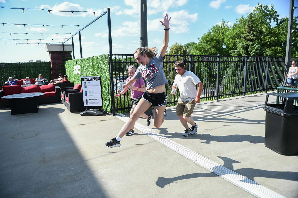 Emily Booms finishes her race with a celebration during the Great Lakes Loons Beer Run on July 2, 2022 at Dow Diamond.