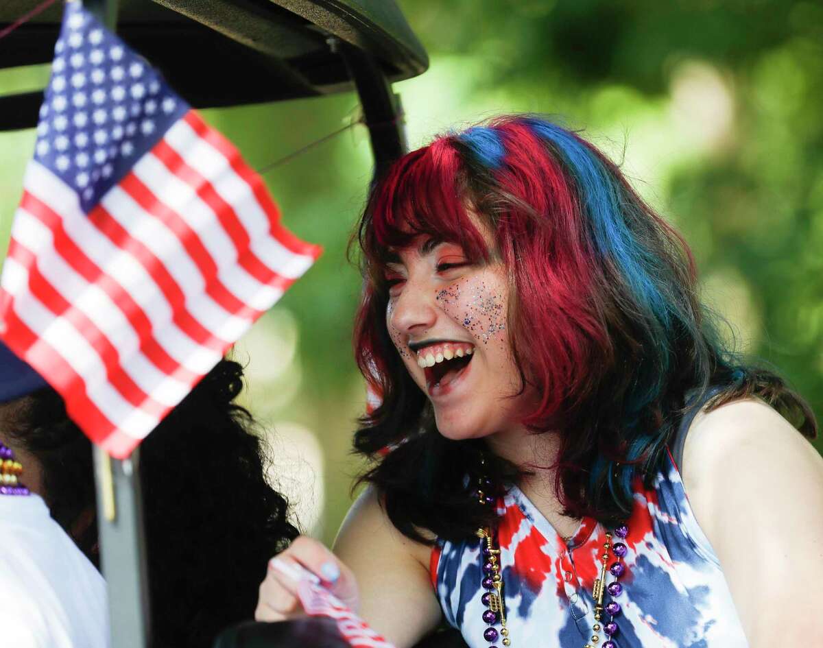 Andrea Mercado laughs as she waits for the annual Fourth of July parade through Panorama Village to begin on Monday. At left, Panorama Village Mayor Lynn Scott laughs while wearing festive glasses. The city also celebrated its 50th anniversary over the weekend.