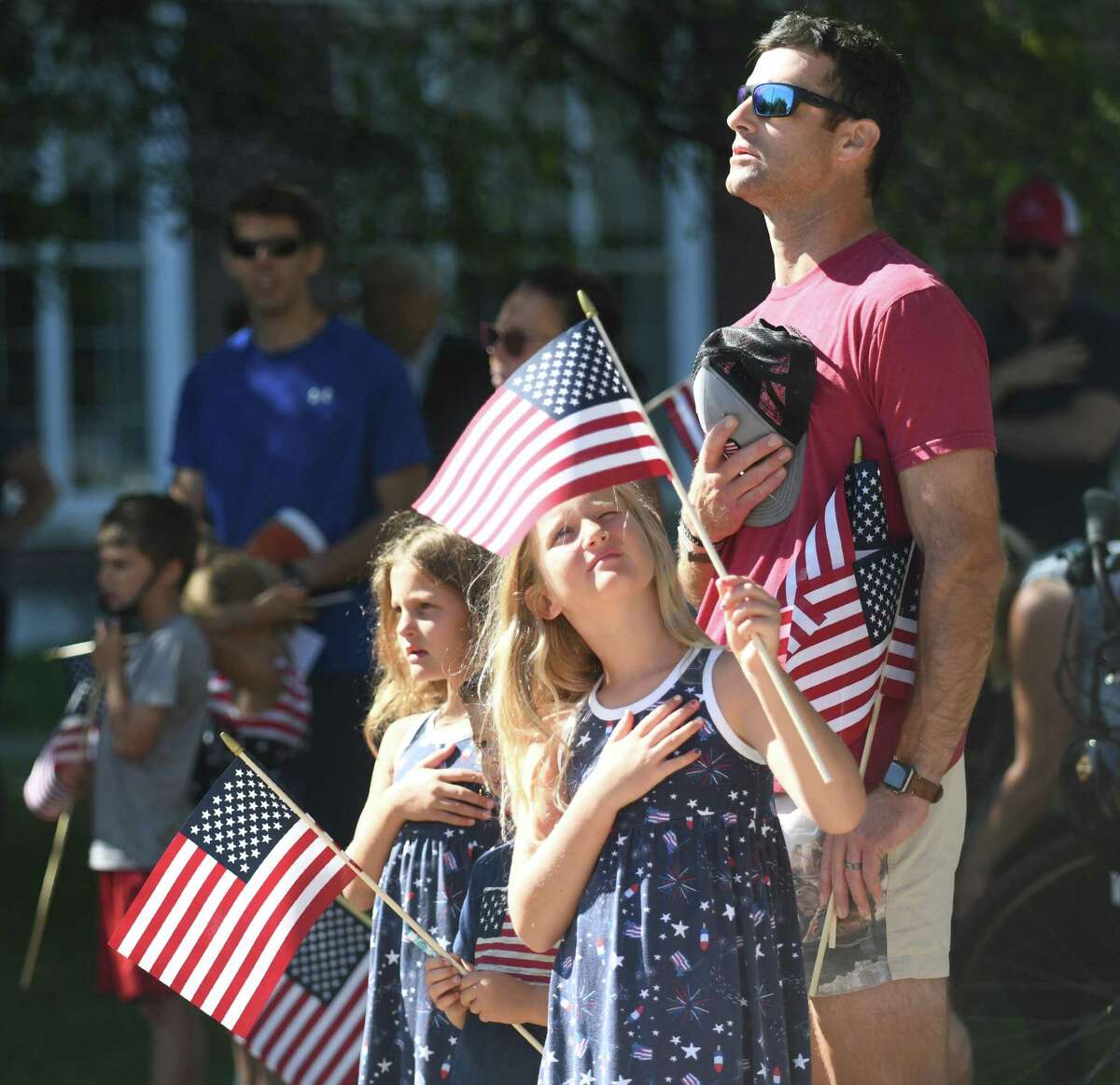 Greenwich's Sage Withrow and his children Ainsley, left, 6, Colt, center, 4, and Reagan, 8, look toward the flag during the singing of the Star Spangled Banner at the Fourth of July Celebration at Greenwich Town Hall in Greenwich, Conn. Monday, July 4, 2022. Presented by the Independence Day Association of Greenwich, the ceremony featured various readings and songs, a raising of the Colonial flag, recognition of the original Greenwich settlers, and reading of the names of Greenwich soldiers killed in the Revolutionary War.