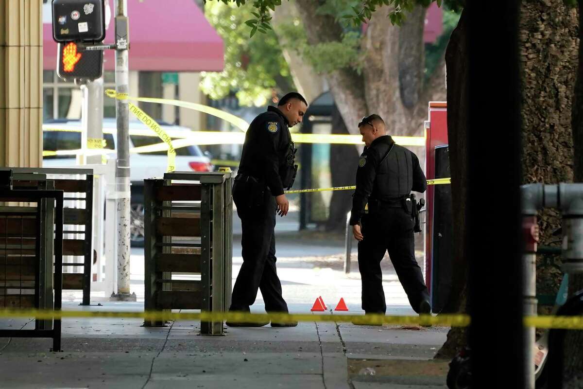Sacramento police look over evidence markers near the scene of a fatal downtown shooting near the state Capitol building.