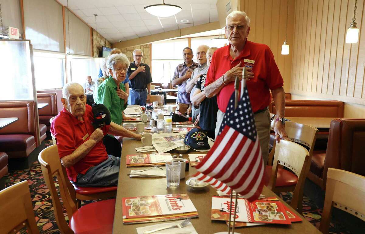 Vietnam veteran Ray Falke (right) and Pearl Harbor veteran K.P. Platt (left) join others in the Pledge of Allegiance as Russell Minor (rear) hosts another breakfast for veterans at Jim's Restaurant last week.