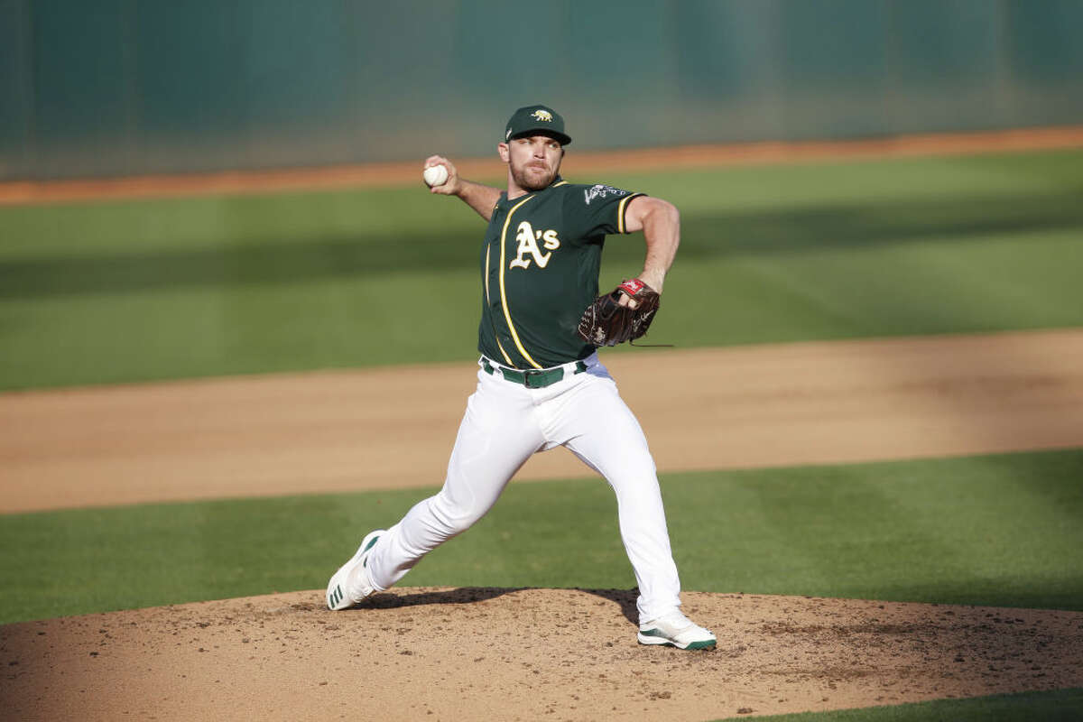 Liam Hendriks, then of the Oakland Athletics, pitches during summer workouts in Oakland, California in 2020.