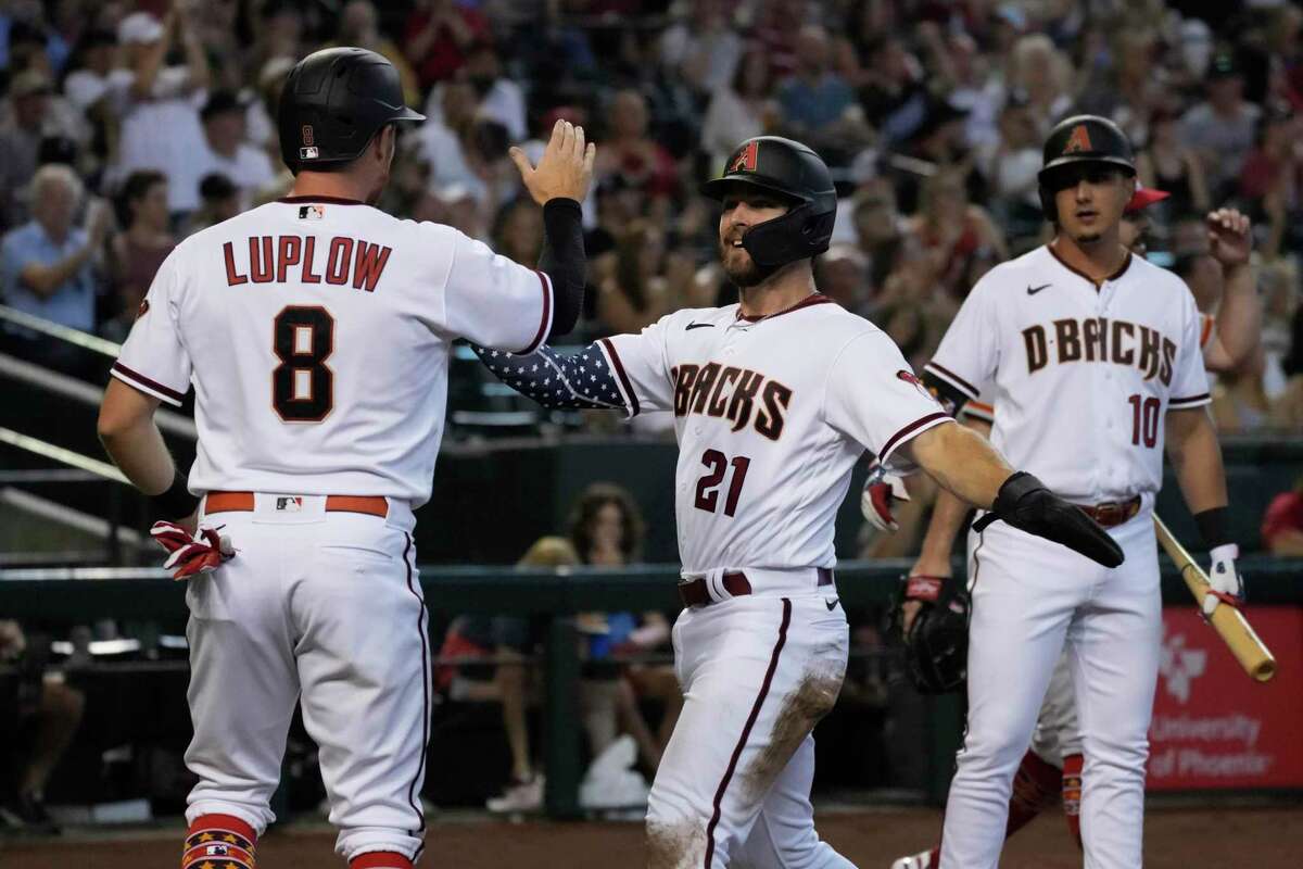 Arizona Diamondbacks' Cooper Hummel (21) and Jordan Luplow (8) celebrate after scoring runs on a ball hit by Buddy Kennedy (not shown) in the first inning during a baseball game against the San Francisco Giants, Monday, July 4, 2022, in Phoenix. (AP Photo/Rick Scuteri)