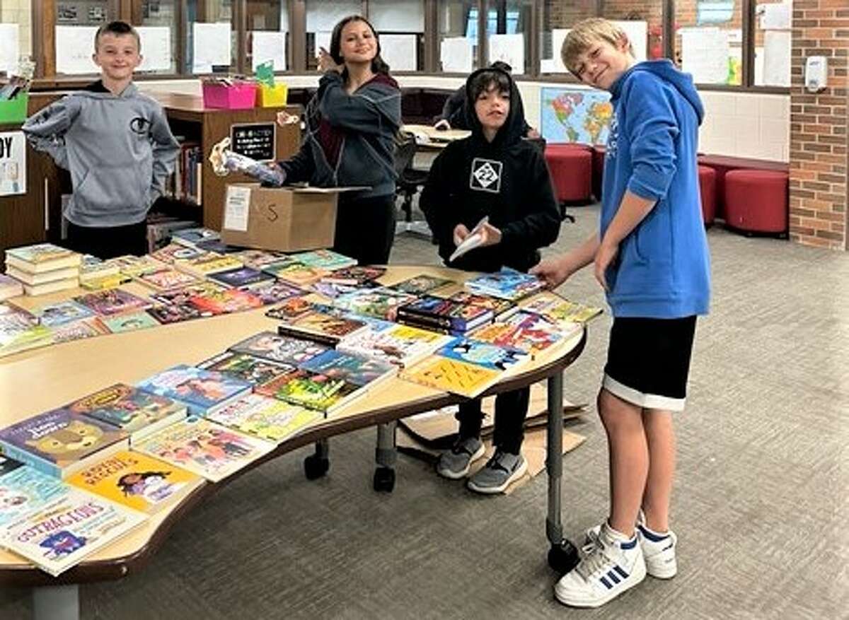 Students from Traverse Heights Elementary School receive books through the PoWeR! Book Bags Vacation Literacy Giveaway.