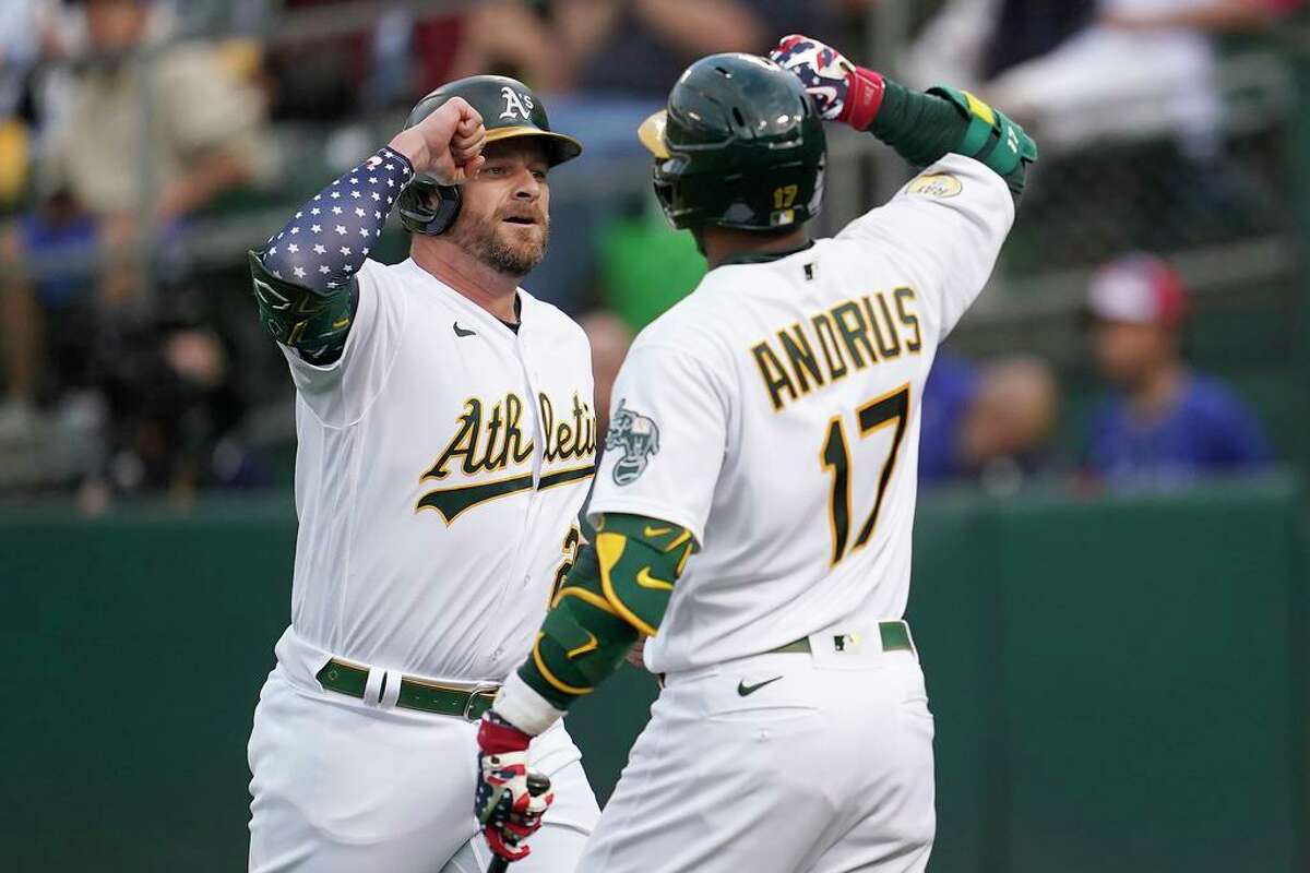 Oakland Athletics' Stephen Vogt, left, is congratulated by Elvis Andrus after hitting a home run against the Toronto Blue Jays during the sixth inning of a baseball game in Oakland, Calif., Monday, July 4, 2022. (AP Photo/Jeff Chiu)