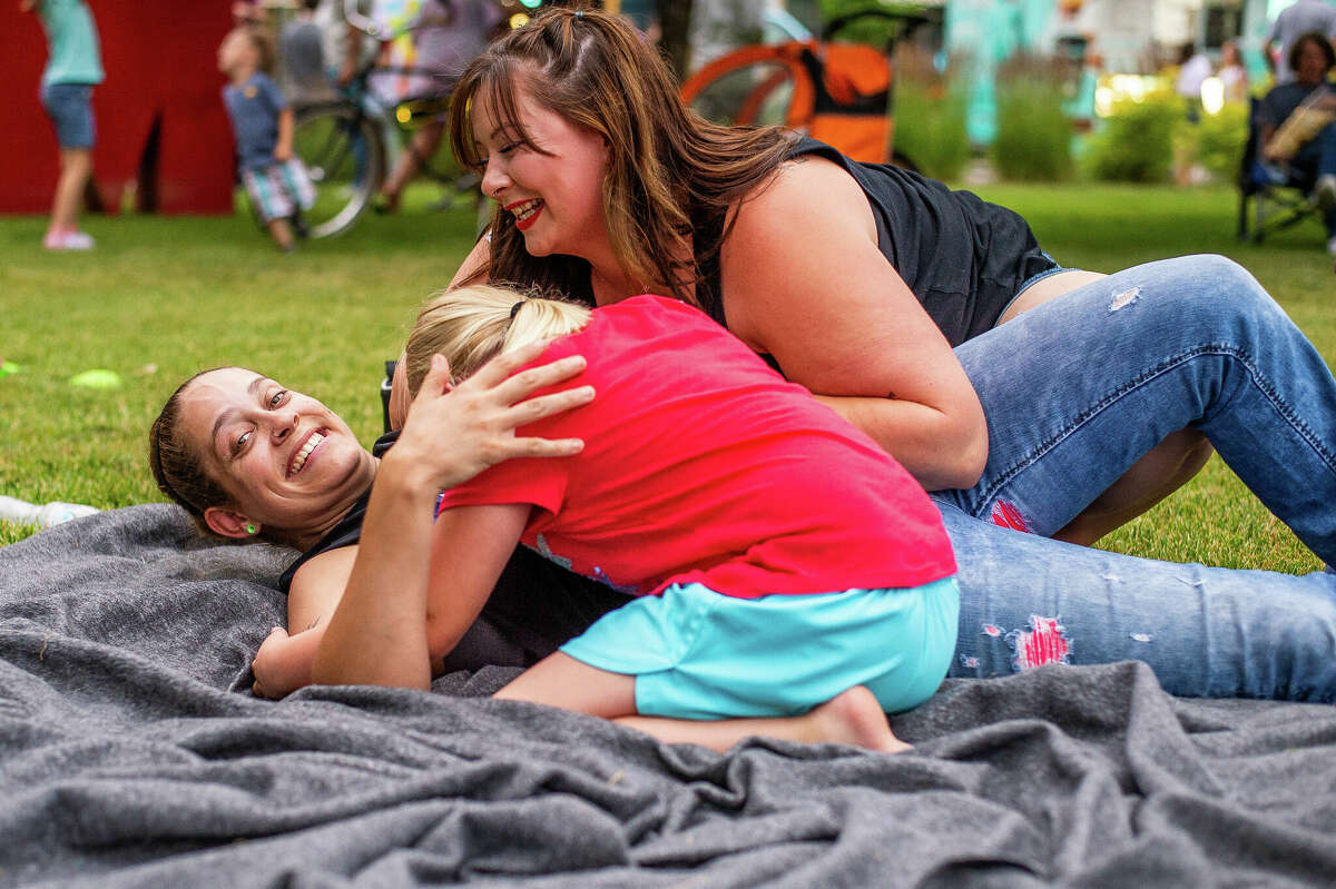 Midland resident Danielle Seymour (left) plays with Midland resident Peyton Brubaker, 7, and Midland before watching fireworks on July 4, 2022 by Dow Diamond in Midland.