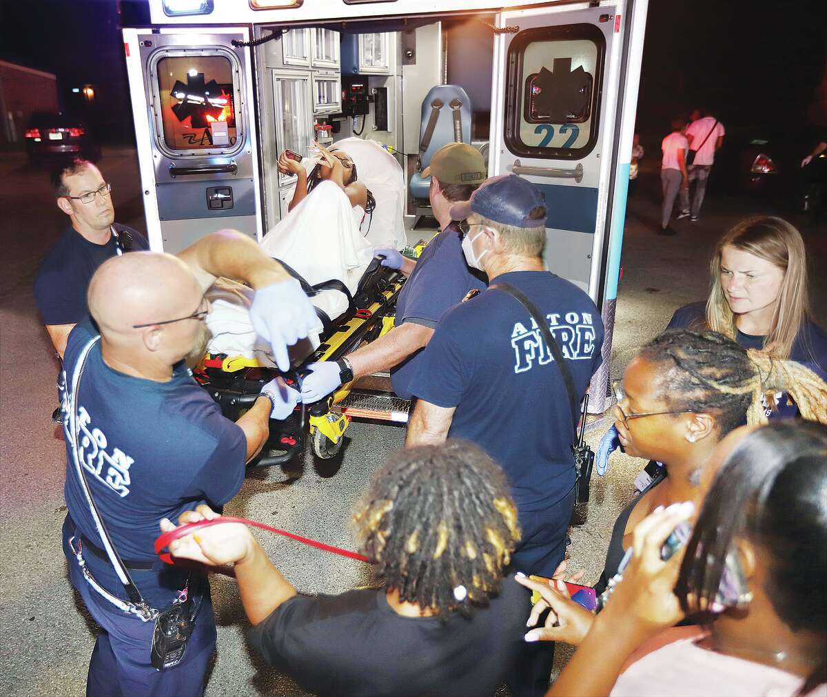 John Badman|The Telegraph First responders load one of two shooting victims into an ambulance late Monday night in the 800 block of Oakwood Avenue in Alton.