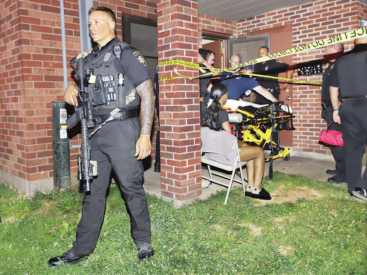 John Badman|The Telegraph An officers stands guard over the double shooting scene Monday night with an assault rifle. Alton Police called for emergency assistance, bringing more than a dozen officers from multiple jurisdictions to the scene to assist.
