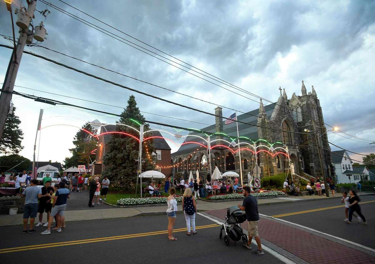 A storm approaches the annual St. Roch's Feast in Greenwich, Conn. on Aug. 8, 2019. Guests of the festival cross St. Roch Avenue to access the event at St. Roch Church and the Hamilton Avenue School parking lot.