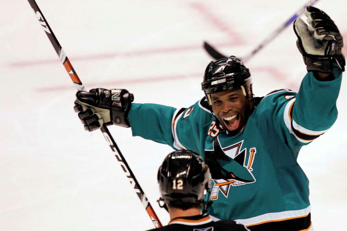 FILE - San Jose Sharks' Mike Grier, top, celebrates with Patrick Marleau (12) after Marleau's third-period goal against the Columbus Blue Jackets during an NHL hockey game in San Jose, Calif., Tuesday, Oct. 14, 2008. The San Jose Sharks have hired longtime NHL forward Mike Grier to become the first Black general manager in NHL history. Grier fills the spot that opened when Doug Wilson stepped away for health reasons earlier this year in a barrier-breaking move for the league on Tuesday, July 5, 2022. (AP Photo/Marcio Jose Sanchez, File)