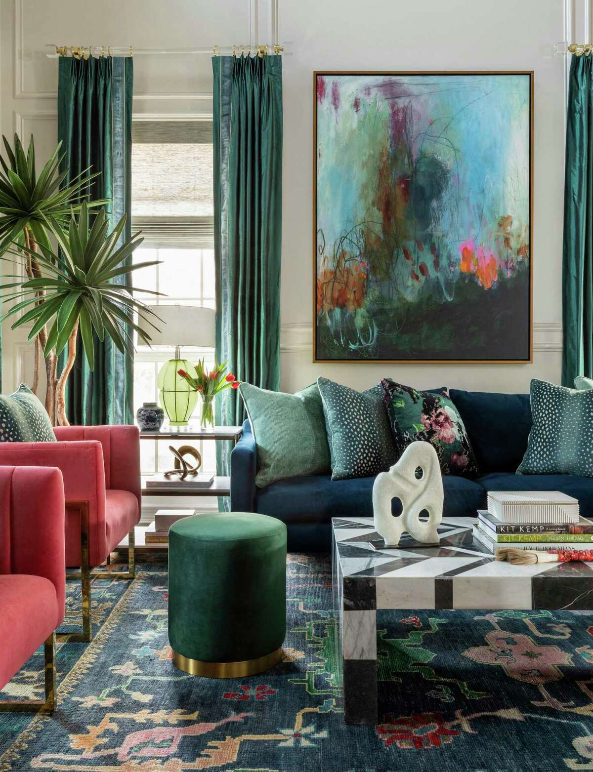 The living room rug sets the palette for the room filled with blue, green and even a little pink.