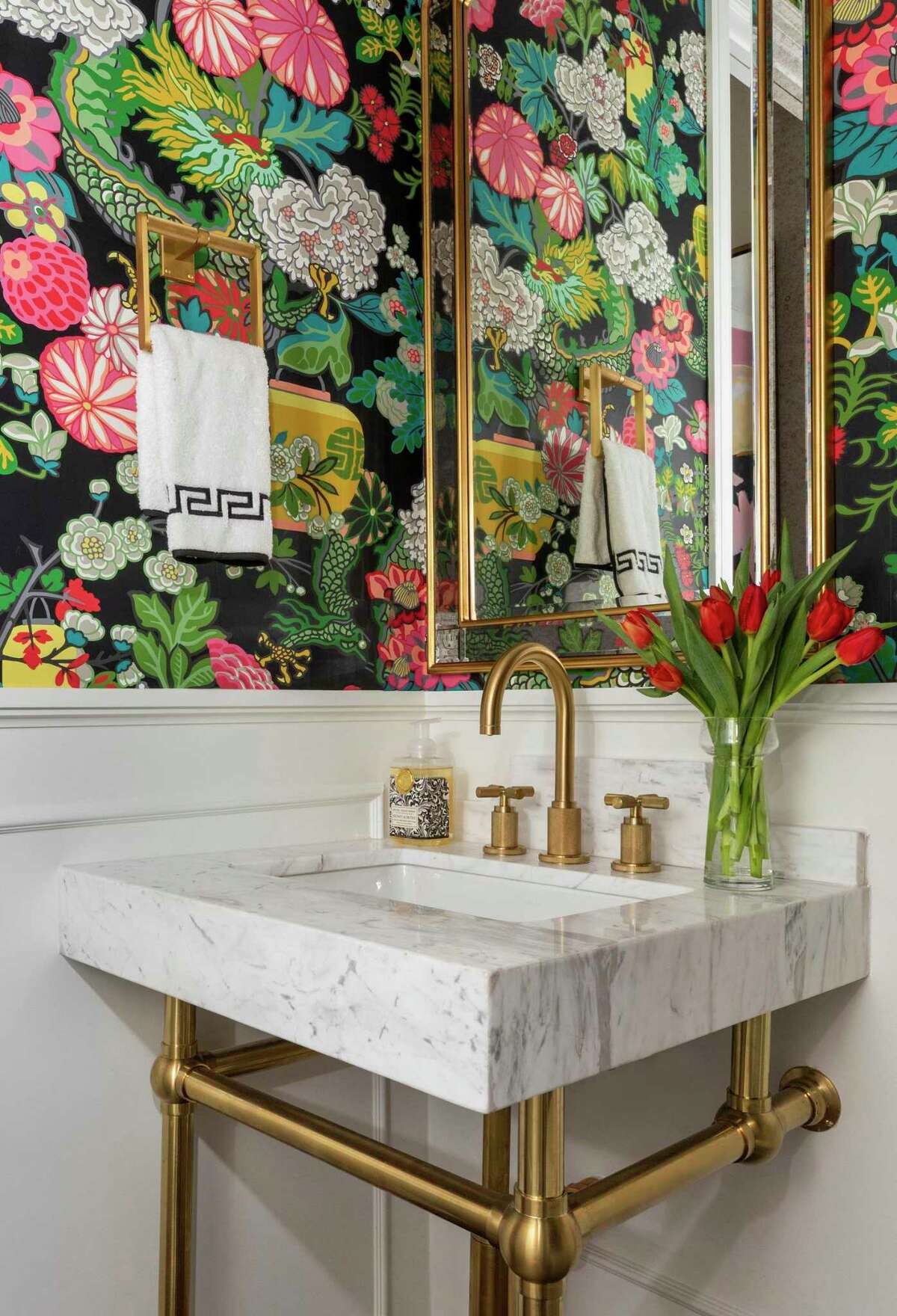 A plain powder-coated bathroom got a makeover with panels and wallpaper with a chinoiserie pattern.