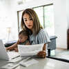STOCK IMAGE Mother working from home while holding baby