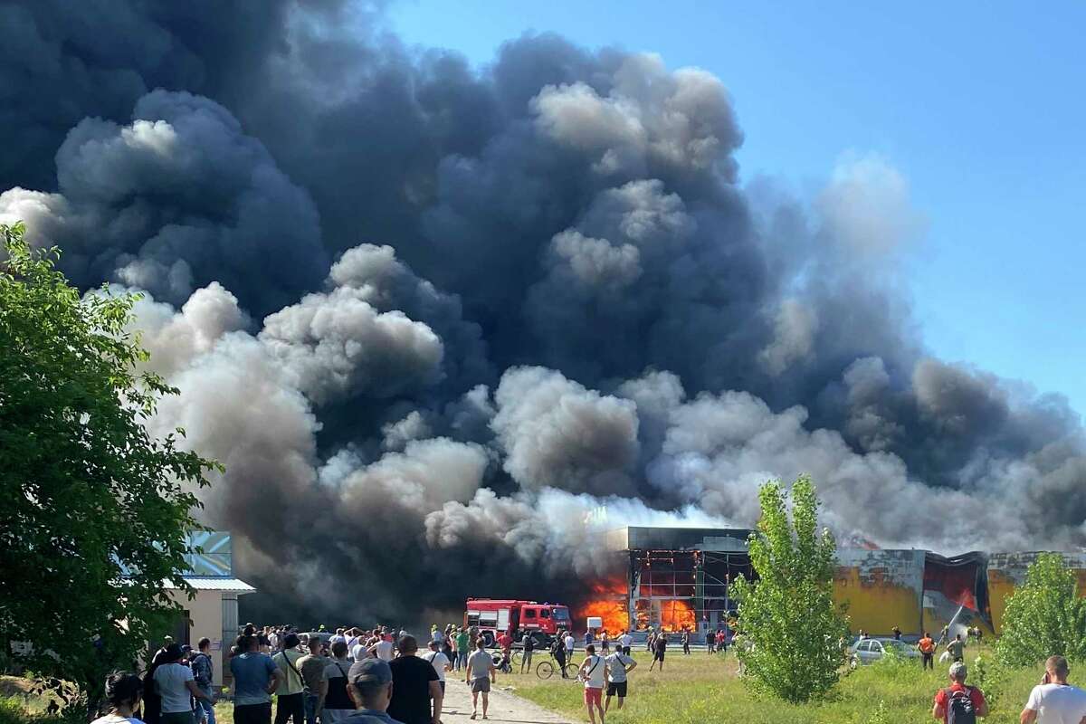FILE - People watch as smoke bellows after a Russian missile strike hit a crowded shopping mall, in Kremenchuk, Ukraine, Monday, June 27, 2022. (Viacheslav Priadko via AP, File)