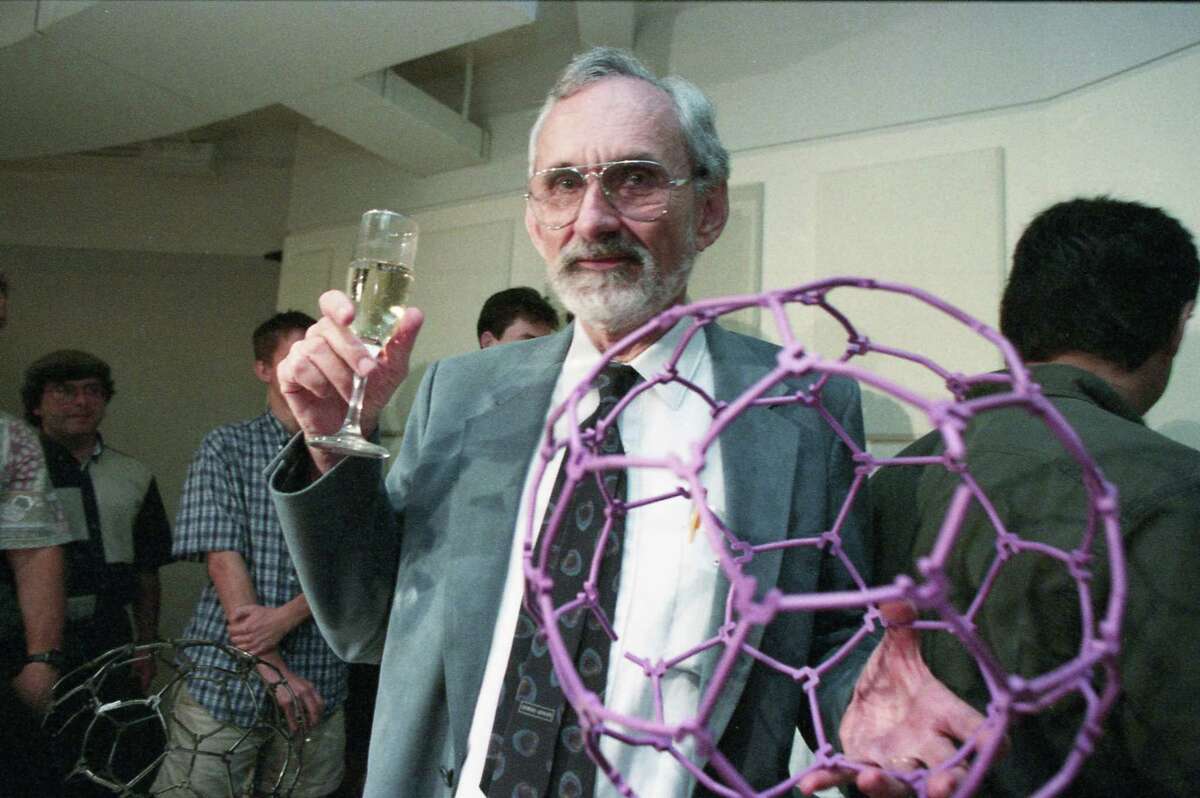 10/09/1996 - Rice University chemistry Professor Robert Curl holds a champagne glass and model of a new carbon molecule he discovered along with fellow Rice Professor Richard E. Smalley and Harry Kroto of the University of Sussex in Brighton, England. The trio were awarded the Nobel Prize in Chemistry, Wednesday, for their 1985 discovery of a family of soccer ball-shaped carbon molecules known unofficially as "buckyballs.''