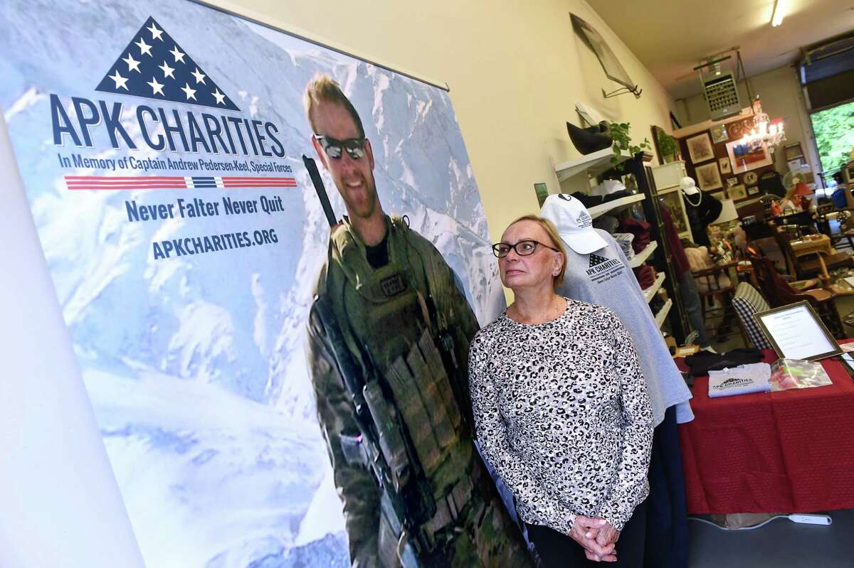 Helen Kaiser-Pedersen, CEO of APK Charities, next to a life-size photograph of her deceased son, Special Forces Captain Andrew Pedersen-Keel, at the entrance to the APK Charities Desert Eagles Nest Thrift Store in Madison on June 30.