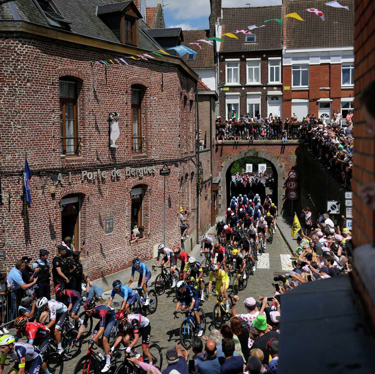 The pack crosses the village of Cassel during the fourth stage of the Tour de France. Belgian rider Wout van Aert surged ahead up the last of the five climbs, about six miles from the end.