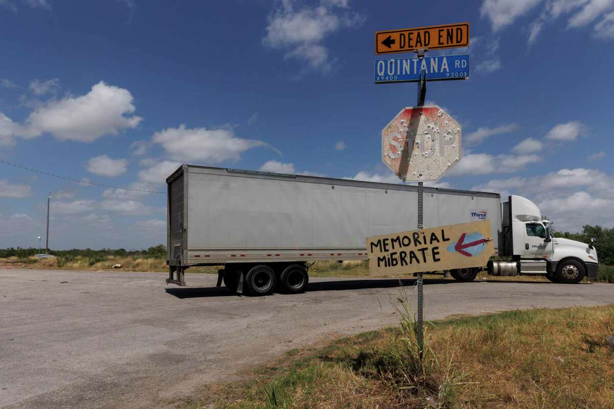 A tractor-trailer drives by the intersection of Cassin Drive and Quintana Road, Tuesday morning, July 5, not far from the site where an abandoned tractor-trailer was found with 67 people inside Monday, June 27. Fifty-three of the migrants have died from heat-related illnesses so far.