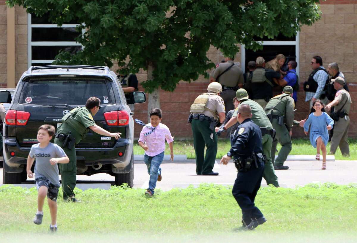 Law enforcement officials evacuate students and staff from Robb Elementary School after a gunman entered a classroom and began shooting on Tuesday, May 24, 2022.