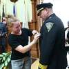 Kelli Jacobson pins the chief’s badge on her father, New Haven Police Chief Karl Jacobson, during a swearing-in ceremony at City Hall in New Haven Wednesday.