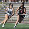 Guilford's Maddie Epke (20) drives towards the net with Cheshire's Grace Downing (2) defending during the SCC girls lacrosse final in West Haven on Thursday, May 26, 2022.