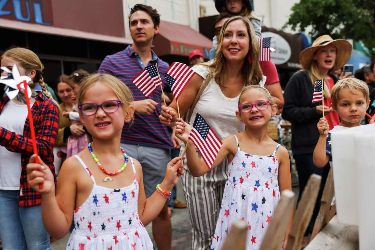 Haley Ganser and her daughters wave flags during the 4th of July Parade in Alameda.