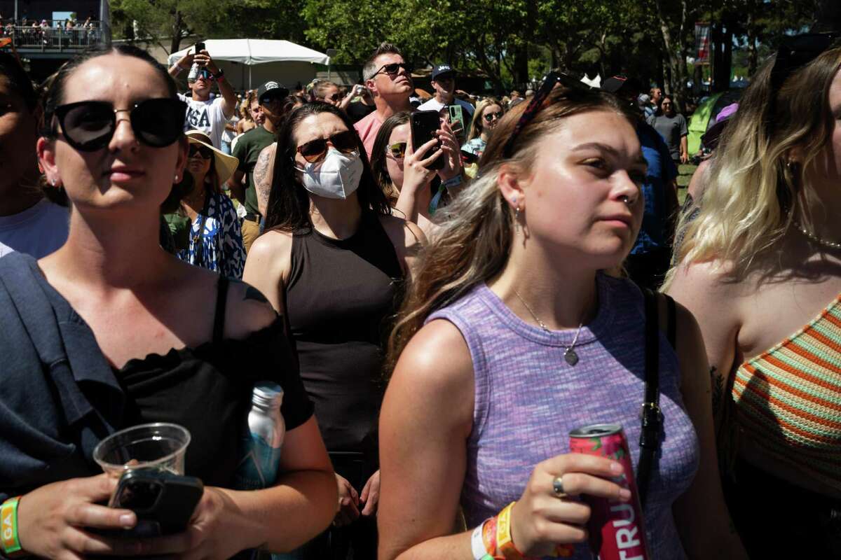 A mask-wearing woman stands in the middle of an unmasked crowd at the BottleRock Napa Valley music festival in May.