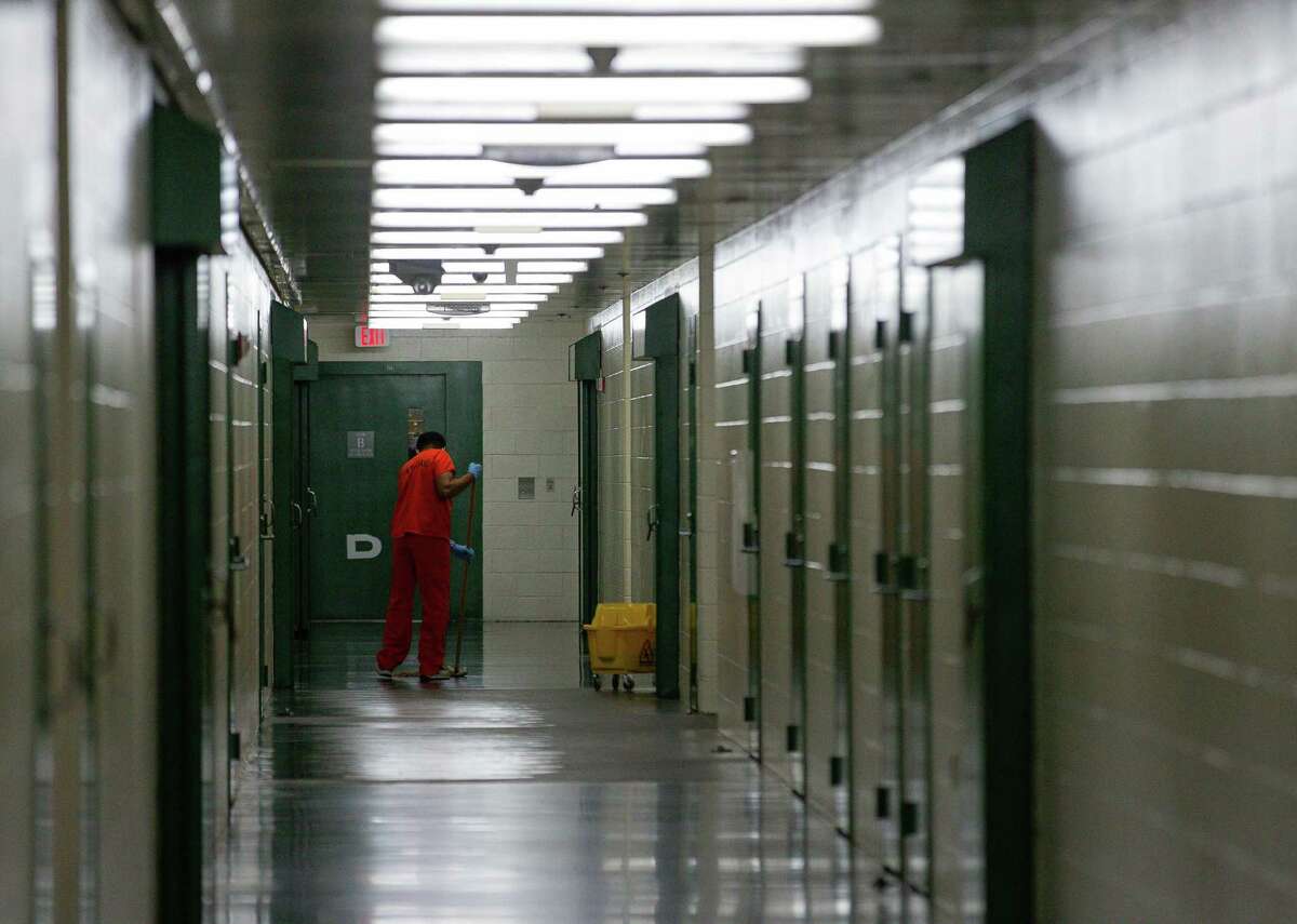 An inmate mops a hallway floor inside the Harris County Jail on Thursday, Jan. 14, 2021, in Houston.