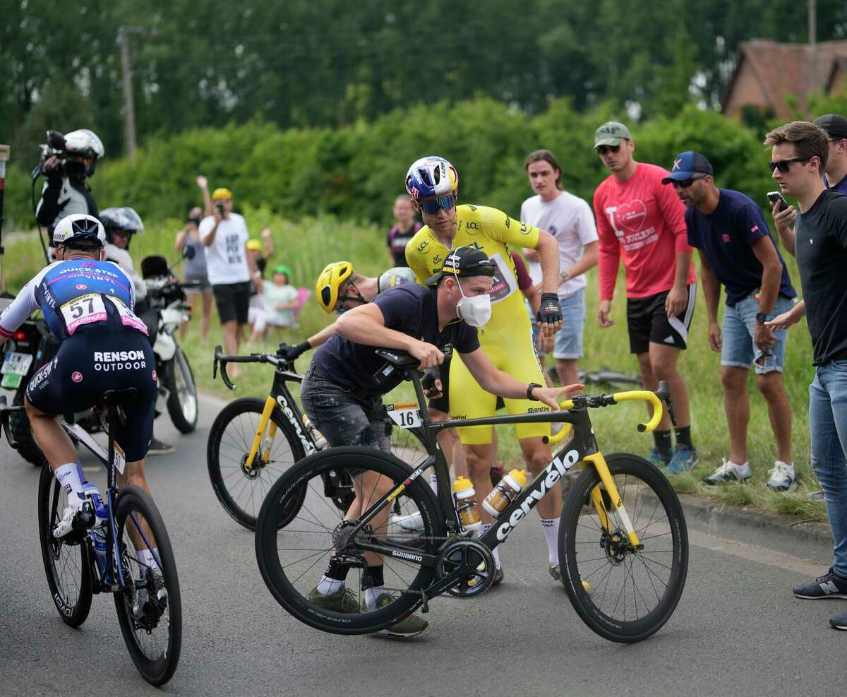 Belgium’s Wout Van Aert, wearing the overall leader's yellow jersey, gets back on his bicycle after crashing in the fifth stage of the Tour de France to Arenberg Porte du Hainaut, France.