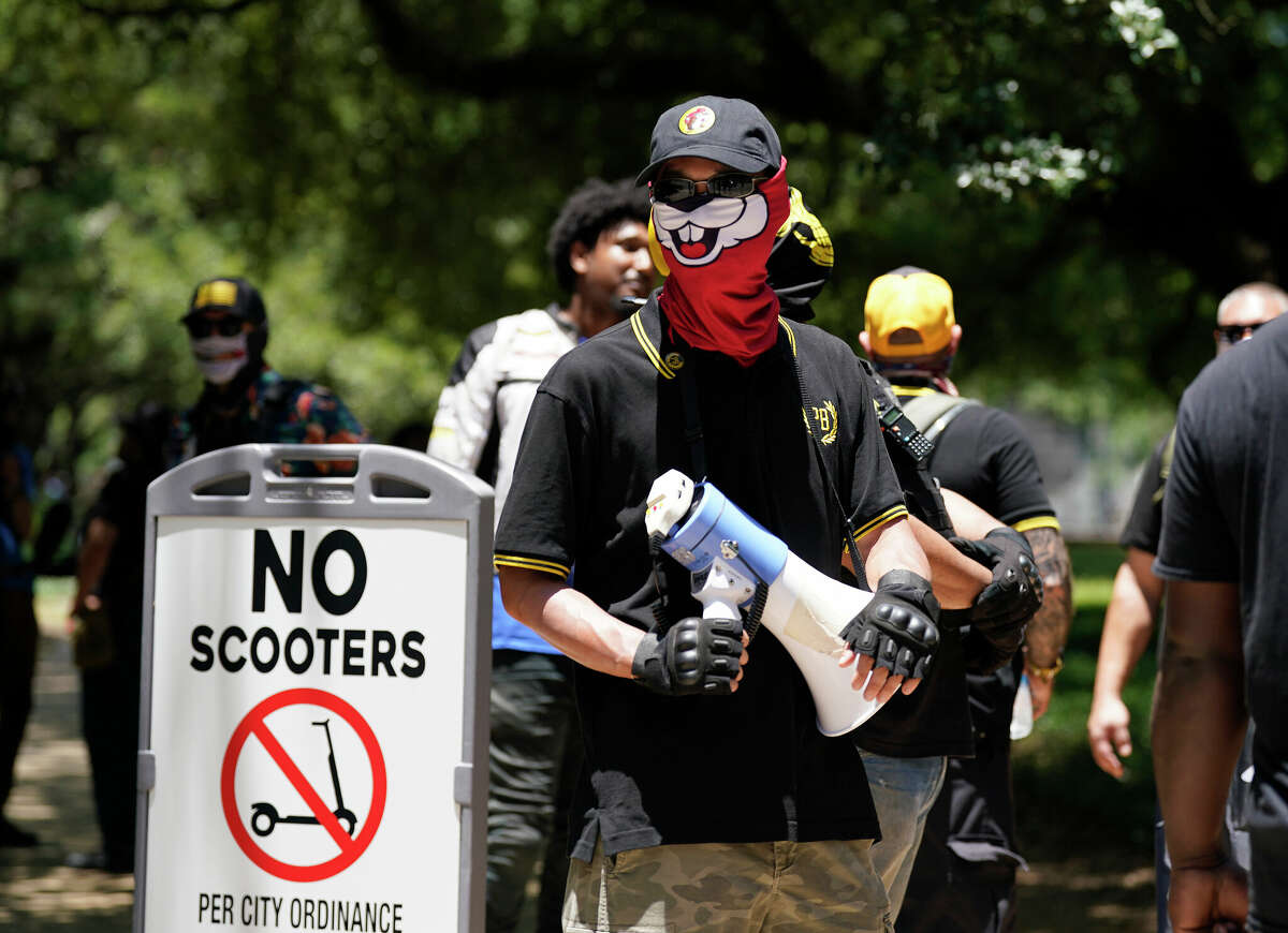Members of the Proud Boys stand inside of their fenced area in Discovery Green across the street from the NRA Convention inside George R. Brown on Saturday, May 28, 2022 in Houston.