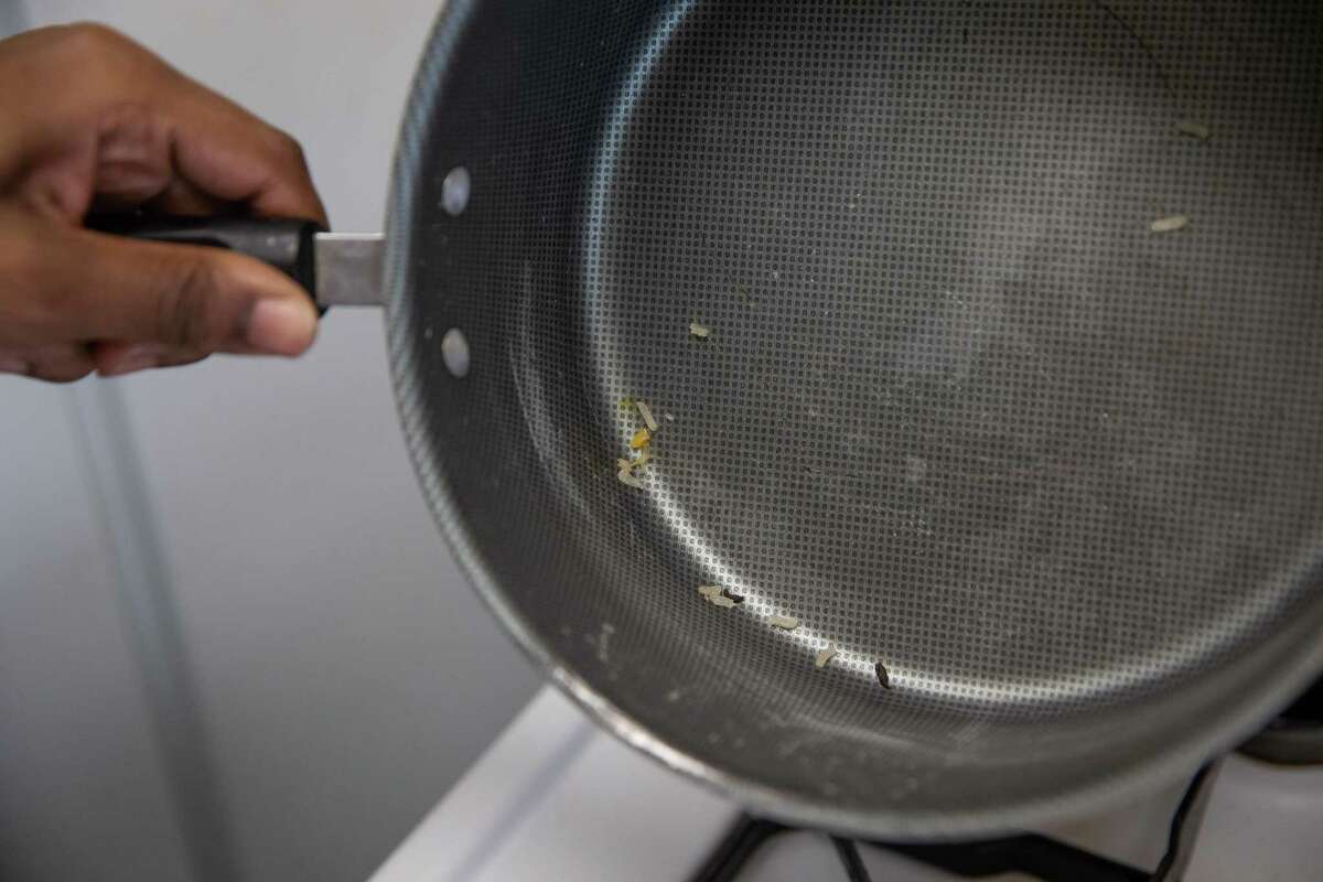 Cleme Manor Apartments resident Danielle Adams shows rat droppings in her cooking pot Wednesday, July 6, 2022, in Houston. Residents say the apartment complex, a HUD-subsidized property in Fifth Ward, has been dealing with power outages, pests, sewer backups and other nuisances for years. Last month, tenants suffered a days-long power outage.