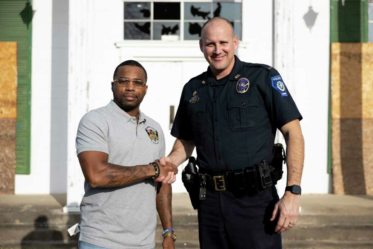LaDon Johnson, left, Conroe Police Lt. Brent Stowe stand in front of the old Conroe Normal & Industrial College during a community project. Johnson is leading a back-to-school supply drive this month in Conroe.