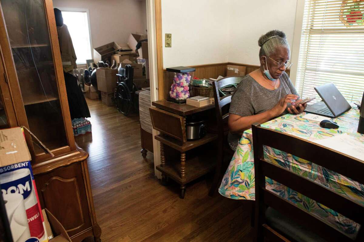 Jaunetta Johns sits at the dining table of her Pleasantville neighborhood home, near the living room filled with boxes and many of her family's possessions Monday, July 26, 2021 in Houston. Her home is slated to be rebuilt as part of a post-Harvey rebuilding program. Many of their possessions are in boxes in their living room, because the rebuild is on hold, because of a dispute with the Texas General Land Office. Mayor Sylvester Turner joined residents of Pleasantville, Sagemont, and other communities urging fairness in the post-Harvey Home rebuilding program through the Texas GLO.