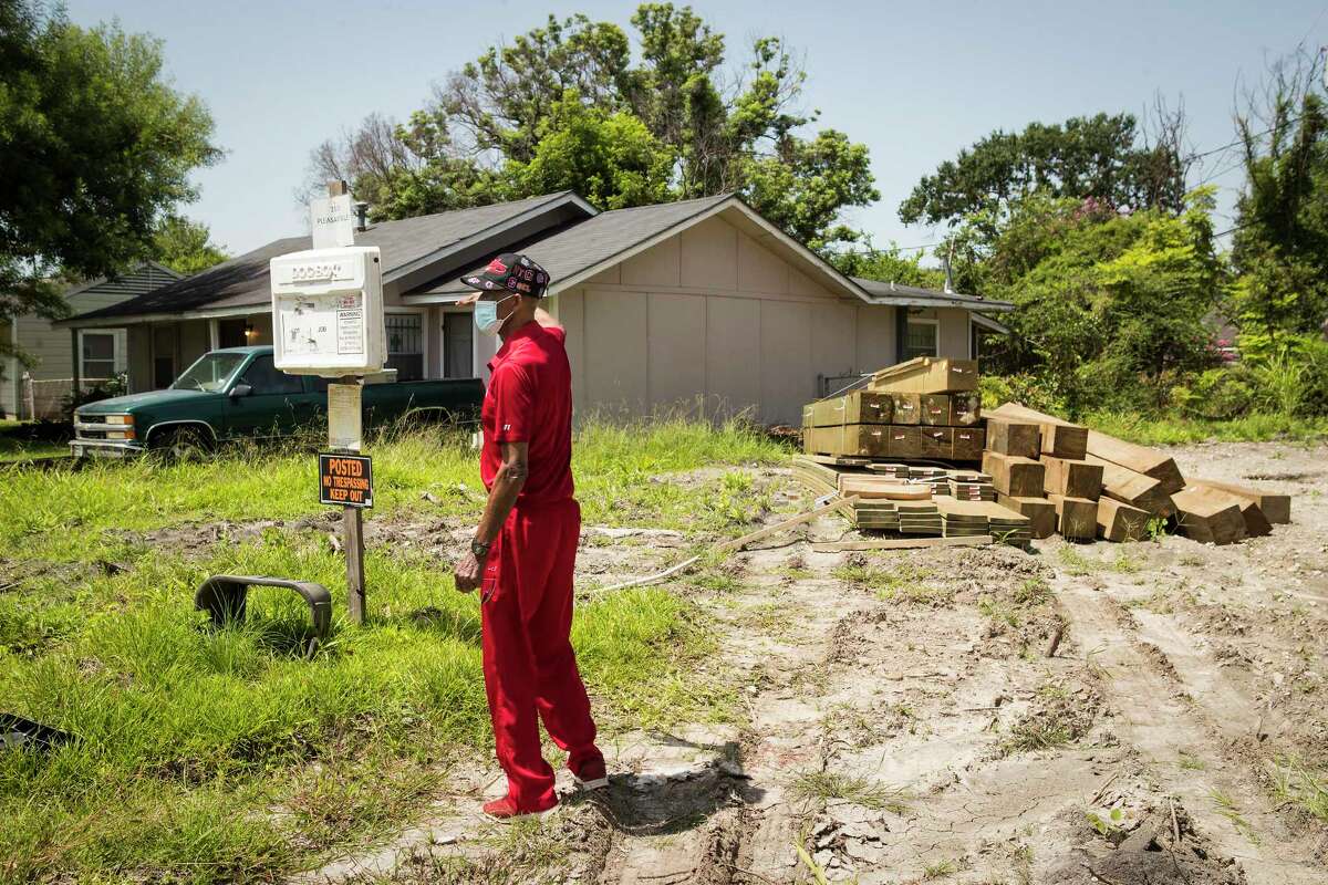 Clinton Johns stands by a lot with supplies to build a piers and beams foundation, which is against the neighborhood's deed restrictions, in the Pleasantville neighborhood Monday, July 26, 2021 in Houston. Mayor Sylvester Turner joined residents of Pleasantville, Sagemont, and other communities urging fairness in the post-Harvey Home rebuilding program through the Texas General Land Office.