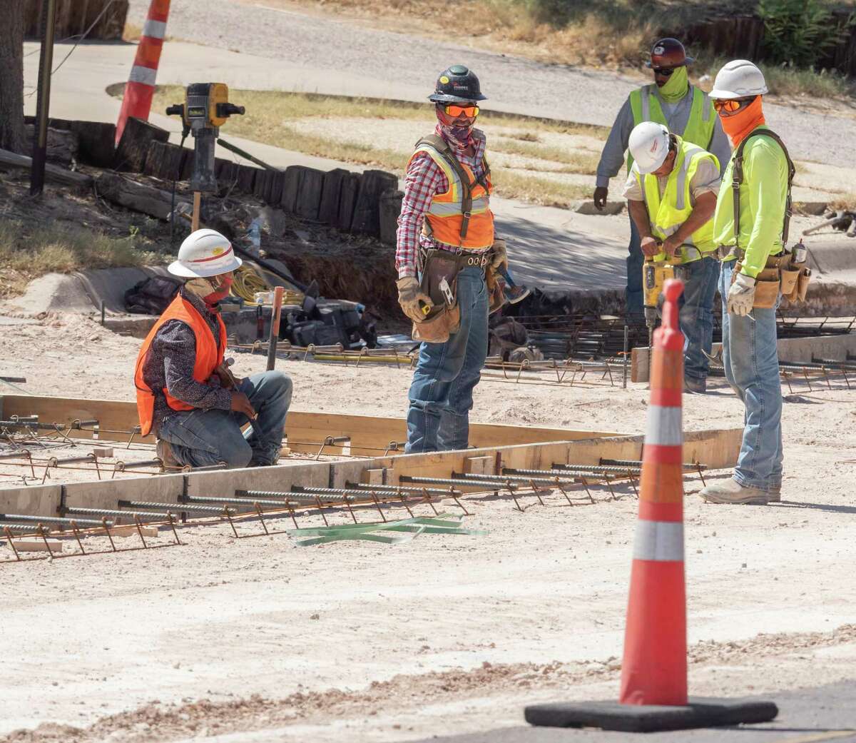 Workers dress in long sleeves, pants and masks in July as they try to stay cool in the 100-degree temperatures as they work on North "A" Street. Tim Fischer/Reporter-Telegram