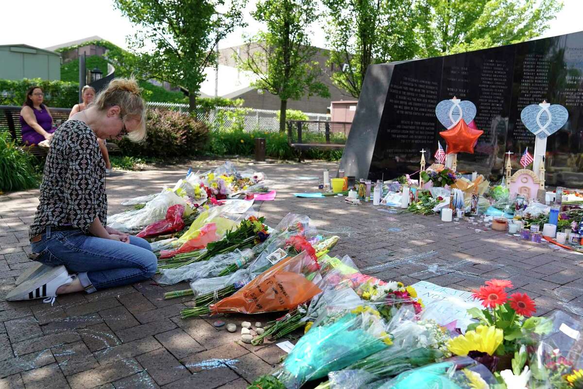Visitors pay respects Thursday at Highland Park War Memorial to the seven people killed and those injured in Monday’s mass shooting in Highland Park, Ill.